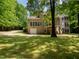 Backyard view of a brick home with a screened-in porch, balcony, and large grassy yard at 540 Vista Del Lago Ln, Wake Forest, NC 27587