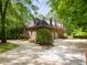 Brick home with three dormers above the garage, surrounded by mature trees and lush greenery at 540 Vista Del Lago Ln, Wake Forest, NC 27587