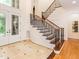Welcoming foyer with curved staircase, tile accents, hardwood floors, and a stylish, stained-glass front door at 540 Vista Del Lago Ln, Wake Forest, NC 27587