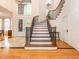 Spacious foyer featuring a grand staircase with wooden treads and iron railing, and decorative glass front doors at 540 Vista Del Lago Ln, Wake Forest, NC 27587