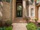 Close-up of the front entrance of brick home, featuring double doors and decorative landscaping at 540 Vista Del Lago Ln, Wake Forest, NC 27587