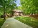 Beautiful brick home surrounded by mature trees and lush landscaping, showcasing its curb appeal at 540 Vista Del Lago Ln, Wake Forest, NC 27587