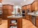 Gourmet kitchen featuring a large island with cooktop, custom wood cabinetry, and stainless steel appliances at 540 Vista Del Lago Ln, Wake Forest, NC 27587
