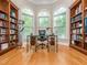 Sunlit home office featuring built-in bookshelves, hardwood floors, and large arched windows at 540 Vista Del Lago Ln, Wake Forest, NC 27587