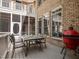 Brick home with an outdoor patio featuring a dining table and chairs on a sunny day at 540 Vista Del Lago Ln, Wake Forest, NC 27587