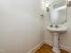 Charming powder room featuring a pedestal sink, decorative mirror, wall sconces, and hardwood floors at 540 Vista Del Lago Ln, Wake Forest, NC 27587