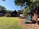Expansive backyard with playhouse, pergola, covered patio, and lush greenery at 603 Hugo St, Durham, NC 27704