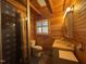 Wood-paneled bathroom with glass shower, modern fixtures, vanity, toilet, and window at 603 Hugo St, Durham, NC 27704