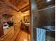 Wood-paneled bathroom with a glass-enclosed shower, vanity, mirror, and adjacent room view at 603 Hugo St, Durham, NC 27704