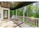 Covered back porch with wood flooring overlooking a lush green backyard at 66 Sweet Meadow Ln, Pittsboro, NC 27312