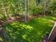 View of the backyard with stairs leading up to a wooden deck at 66 Sweet Meadow Ln, Pittsboro, NC 27312