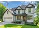 Beautiful home featuring black-framed windows, a manicured lawn, and an attached two-car garage at 66 Sweet Meadow Ln, Pittsboro, NC 27312