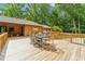 Wooden deck with outdoor seating, perfect for enjoying the surrounding lush greenery and open-air dining at 6971 Shady Creek Trl, Rougemont, NC 27572