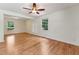Spacious living room with hardwood floors, ample natural light from large windows, and a ceiling fan, creating a welcoming atmosphere at 6971 Shady Creek Trl, Rougemont, NC 27572