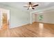 Open-concept living room featuring hardwood floors, a ceiling fan, and seamless transitions to other rooms, offering a spacious and modern feel at 6971 Shady Creek Trl, Rougemont, NC 27572