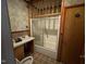 Bathroom features shower with glass doors, sink and vintage wallpaper at 705 Washington St, Graham, NC 27253