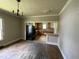 Dining room with view into the kitchen; features wood trim and floors at 705 Washington St, Graham, NC 27253