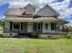 Charming home with a covered front porch, black iron railings, and a spacious front lawn at 705 Washington St, Graham, NC 27253