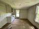 Empty room with neutral walls and carpet features natural light from two windows at 705 Washington St, Graham, NC 27253