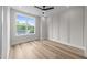 Bright bedroom featuring hardwood floors, a ceiling fan, and a large window at 710 W North St # 101, Raleigh, NC 27603
