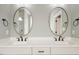 Elegant bathroom featuring double vanity with modern fixtures and oval mirrors at 80 Water Willow Ln, Zebulon, NC 27597