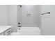Bathroom featuring grey tile in tub surround and updated plumbing fixtures at 80 Water Willow Ln, Zebulon, NC 27597