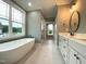 Luxurious bathroom featuring a freestanding tub, double vanities, and a seamless glass shower for a spa-like experience at 80 Water Willow Ln, Zebulon, NC 27597