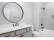 Bathroom with modern fixtures, a large mirror, and a tile surround tub at 80 Water Willow Ln, Zebulon, NC 27597