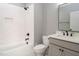 Bathroom featuring a tub-shower combo with white subway tiles, grey vanity with black fixtures, and modern toilet at 80 Water Willow Ln, Zebulon, NC 27597