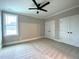 Carpeted bedroom with bright window, ceiling fan and double closets at 80 Water Willow Ln, Zebulon, NC 27597