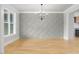 Spacious dining area with decorative accent wall, chandelier, and hardwood floors for a modern design at 80 Water Willow Ln, Zebulon, NC 27597