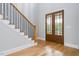 Inviting entryway features hardwood floors, a staircase with dark iron railings, and elegant glass paneled double doors at 80 Water Willow Ln, Zebulon, NC 27597