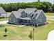 Elegant two-story home boasts lush landscaping and a covered front porch with classic architectural details at 80 Water Willow Ln, Zebulon, NC 27597