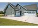 Spacious three-car garage with white doors and ample parking space on a concrete driveway at 80 Water Willow Ln, Zebulon, NC 27597