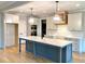 Well-equipped kitchen featuring a large island, modern lighting, and stainless steel appliances for culinary enthusiasts at 80 Water Willow Ln, Zebulon, NC 27597