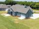 Back of home with screened in porch, well manicured lawn, and a spacious driveway at 80 Water Willow Ln, Zebulon, NC 27597