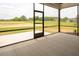 Open screened-in porch overlooking a lush green yard and featuring concrete flooring at 80 Water Willow Ln, Zebulon, NC 27597