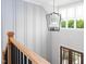 This staircase landing features a modern chandelier and wainscoting along the walls for added elegance at 80 Water Willow Ln, Zebulon, NC 27597