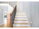 Elegant staircase with wood and black railing, leading to the upper level of the home at 80 Water Willow Ln, Zebulon, NC 27597