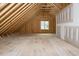 Spacious unfinished attic featuring exposed rafters, a window, and potential for customization at 80 Water Willow Ln, Zebulon, NC 27597