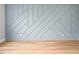 Accent wall with light blue geometric design and hardwood floor at 80 Water Willow Ln, Zebulon, NC 27597
