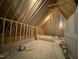 Spacious unfinished attic featuring exposed wood beams and ample potential for customization and future living space at 90 Water Willow Ln, Zebulon, NC 27597