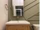 Bathroom featuring a square sink, bronze hardware, and green accent wall at 90 Water Willow Ln, Zebulon, NC 27597