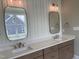Contemporary bathroom with dual sinks, elegant mirrors, and white wall paneling at 90 Water Willow Ln, Zebulon, NC 27597