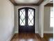 Elegant entryway featuring a dark wood double front door with decorative glass and wooden beams at 90 Water Willow Ln, Zebulon, NC 27597