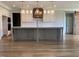 Open-concept kitchen featuring a large island with pendant lights, white cabinets, and modern appliances at 90 Water Willow Ln, Zebulon, NC 27597