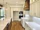 Modern kitchen with white cabinets, stainless steel appliances, hardwood floors and an island with a farmhouse sink at 90 Water Willow Ln, Zebulon, NC 27597