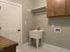 Well-organized laundry room with utility sink, cabinet storage and convenient shelving at 90 Water Willow Ln, Zebulon, NC 27597