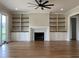Spacious living room features hardwood floors, fireplace with marble surround, and custom built-in shelving at 90 Water Willow Ln, Zebulon, NC 27597
