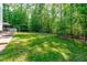 Lush backyard featuring a well-maintained lawn, mature trees, and fenced area at 9021 Albatross Ct, Raleigh, NC 27613